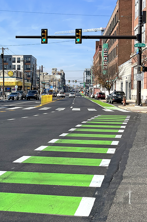 A photograph of a green painted bike lane as it crosses an intersection 