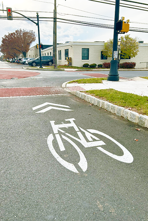 A photo of a bike lane symbol painted on a street