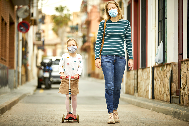 Masked mother and daughter commuting to school