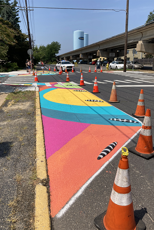 A photo of a temporary installation of traffic calming elements including street painting