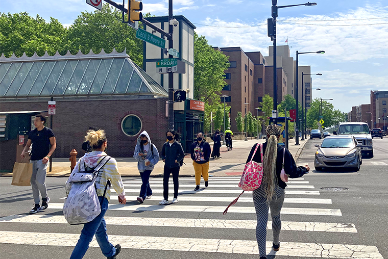 People walking in a cross walk on Cecil B. Moore Avenue in Philadelphia