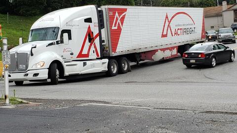 A semi-truck pulling out of a parking lot